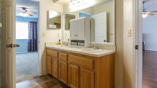 bathroom featuring dual bowl vanity, tile floors, ceiling fan, and a textured ceiling