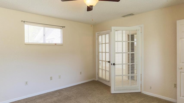 unfurnished room featuring a textured ceiling, ceiling fan, and carpet