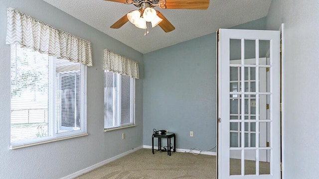 carpeted spare room with a textured ceiling and ceiling fan