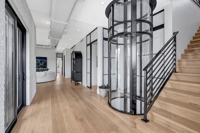 hall with a chandelier and light hardwood / wood-style flooring