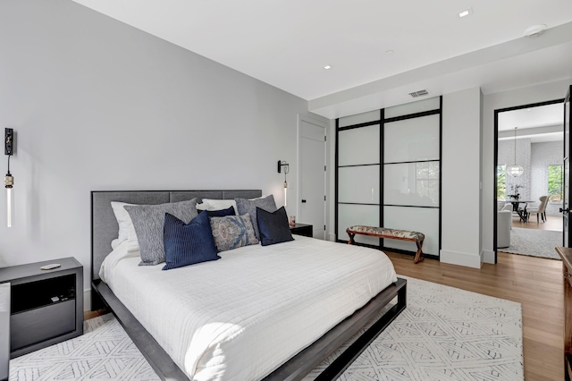 bedroom with a chandelier and light hardwood / wood-style floors