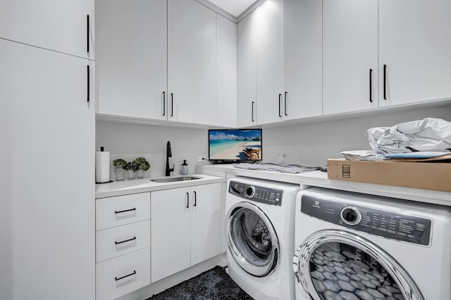 clothes washing area featuring separate washer and dryer, cabinets, and sink