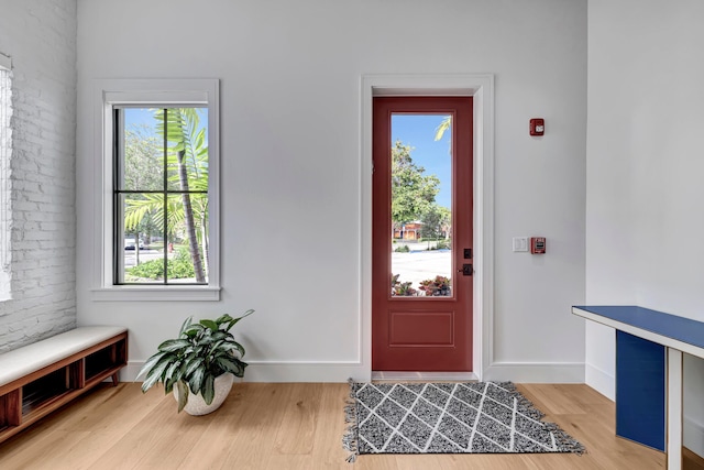 entrance foyer with brick wall and light wood-type flooring