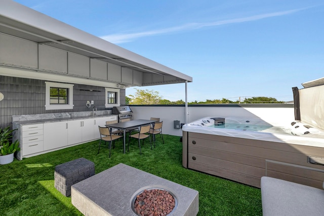 view of patio with area for grilling, an outdoor fire pit, and a hot tub