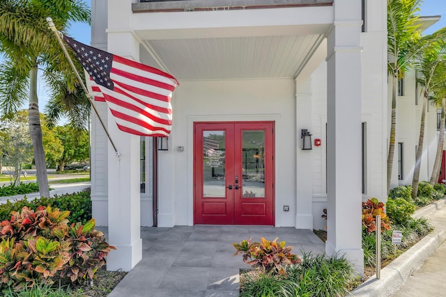 doorway to property featuring covered porch and french doors