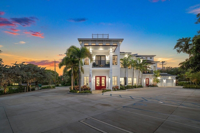 view of front of house featuring a balcony and french doors