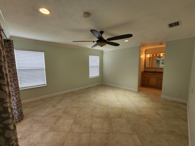 interior space featuring ornamental molding, ceiling fan, light tile floors, and sink