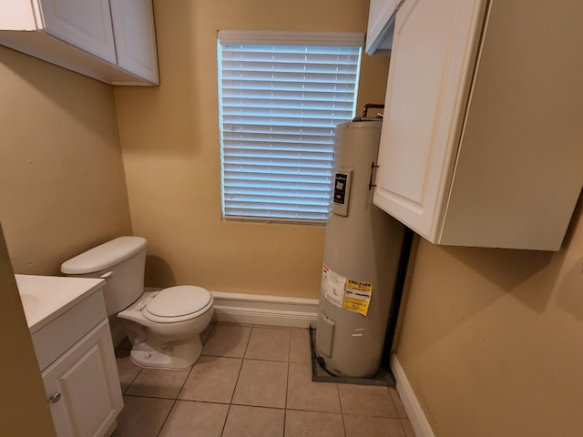 bathroom with vanity, a healthy amount of sunlight, tile floors, electric water heater, and toilet