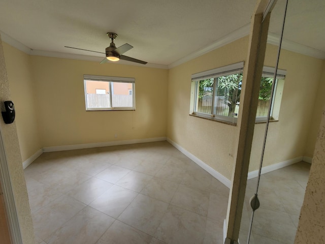 spare room with plenty of natural light, crown molding, ceiling fan, and light tile floors