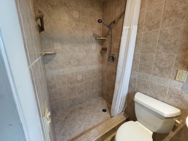 bathroom featuring tile walls, toilet, and a tile shower