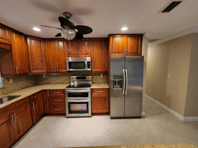 kitchen featuring backsplash, ceiling fan, light tile flooring, appliances with stainless steel finishes, and ornamental molding