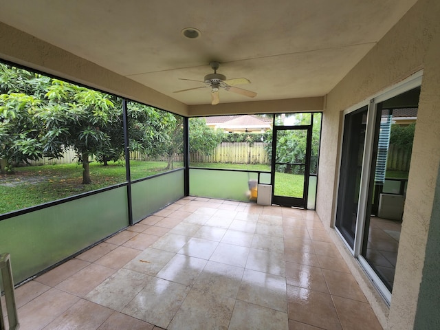 unfurnished sunroom with ceiling fan