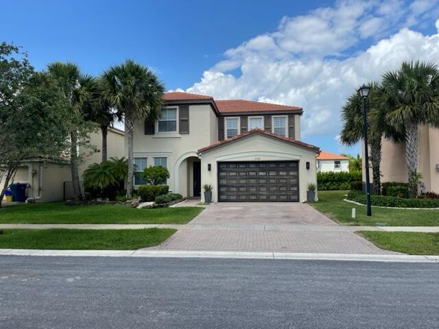 mediterranean / spanish home featuring a front yard and a garage