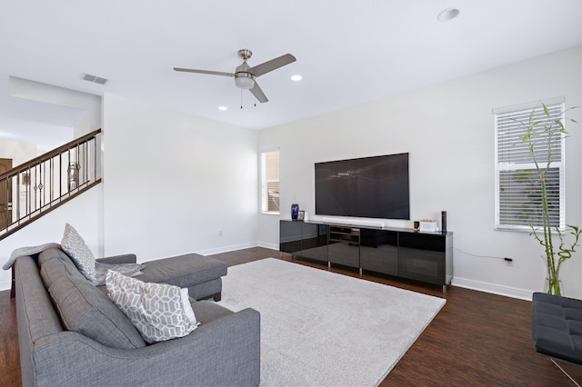 living room with ceiling fan, dark wood-type flooring, and a wealth of natural light