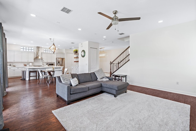 living room with dark hardwood / wood-style floors and ceiling fan with notable chandelier