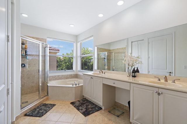 bathroom with tile flooring, independent shower and bath, oversized vanity, and dual sinks