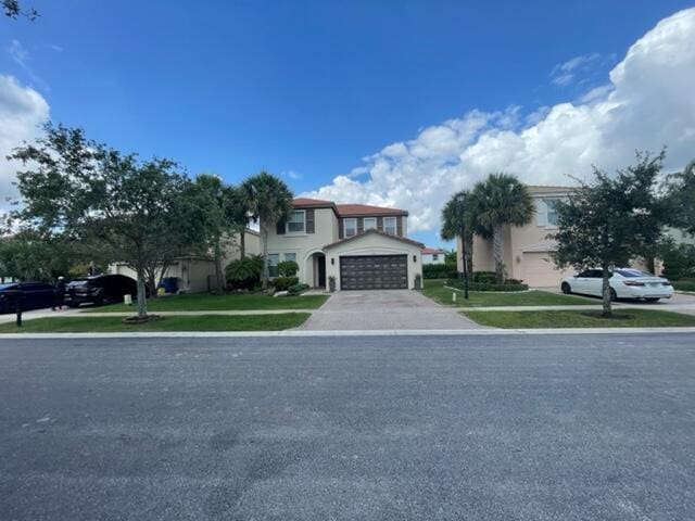 view of front of property with a front yard and a garage