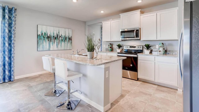 kitchen featuring white cabinets, a center island with sink, and appliances with stainless steel finishes