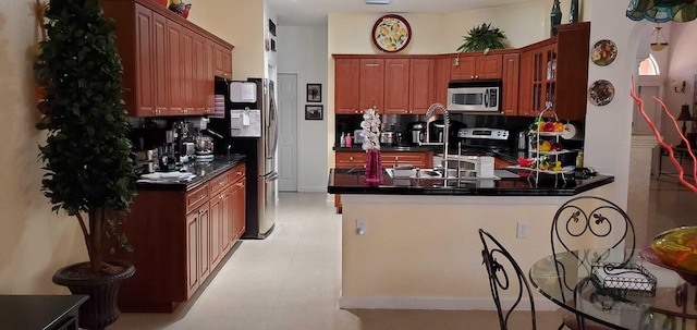 kitchen with light tile flooring, tasteful backsplash, stainless steel appliances, and kitchen peninsula