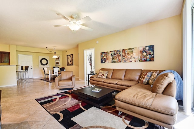 tiled living room with a textured ceiling and ceiling fan