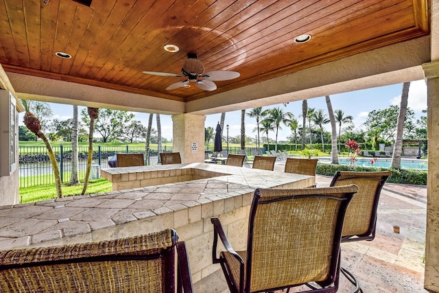 view of patio featuring an outdoor bar and ceiling fan