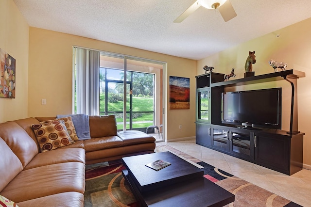 living room featuring ceiling fan, light tile floors, and a textured ceiling