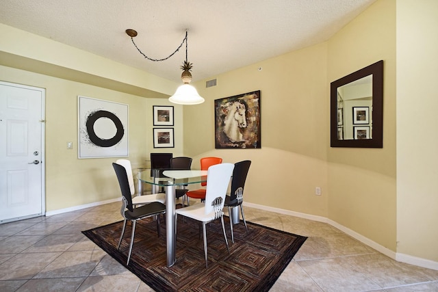 tiled dining room featuring a textured ceiling