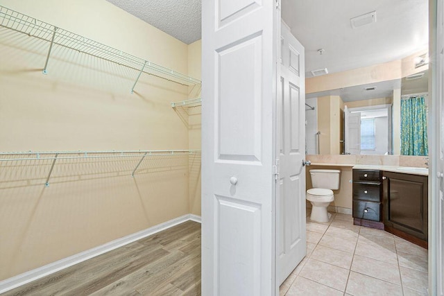 bathroom with toilet, vanity, and wood-type flooring