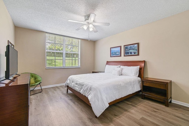 bedroom featuring a textured ceiling, ceiling fan, and light hardwood / wood-style flooring