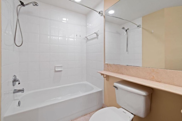 bathroom featuring tiled shower / bath combo and toilet