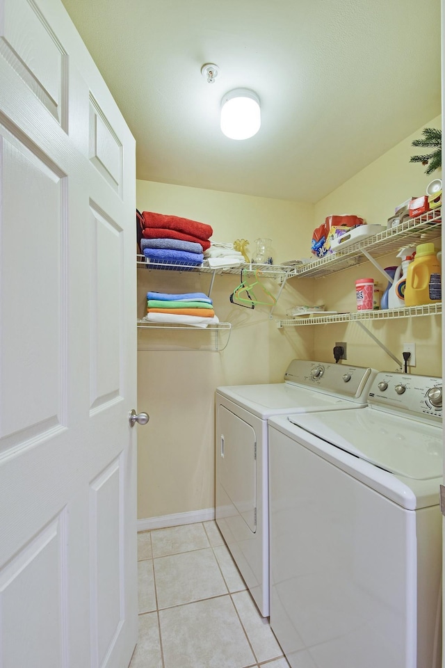 laundry area with hookup for an electric dryer, light tile flooring, and washer and dryer