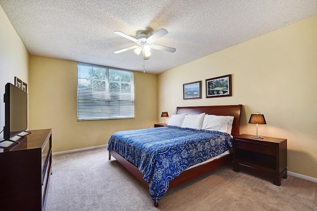 carpeted bedroom featuring a textured ceiling and ceiling fan