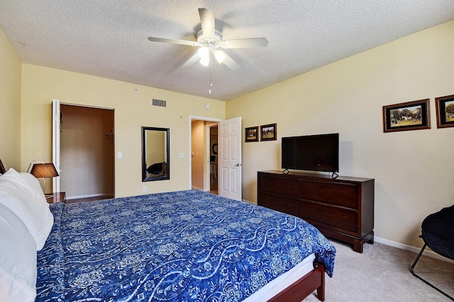 bedroom with light carpet, a textured ceiling, and ceiling fan