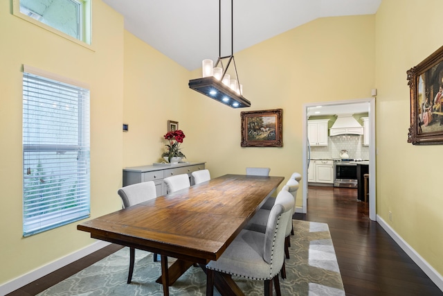 dining area featuring dark hardwood / wood-style floors and vaulted ceiling