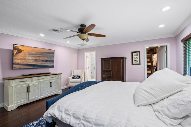 bedroom with ceiling fan, ornamental molding, dark wood-type flooring, and connected bathroom