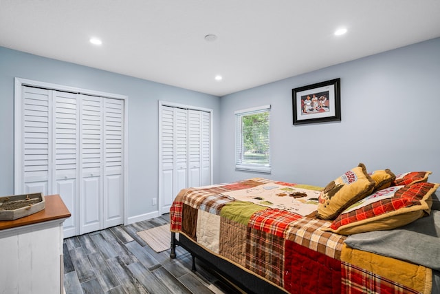 bedroom with multiple closets and dark hardwood / wood-style flooring