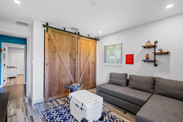 living room featuring a barn door and hardwood / wood-style flooring