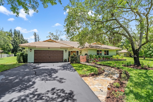 single story home with a front yard and a garage