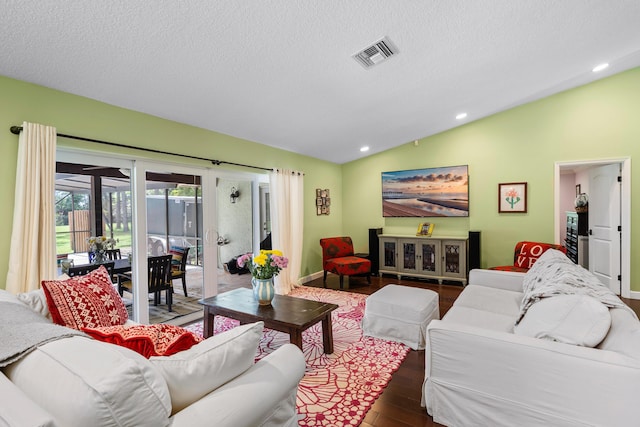 living room featuring a textured ceiling, dark wood-type flooring, and vaulted ceiling