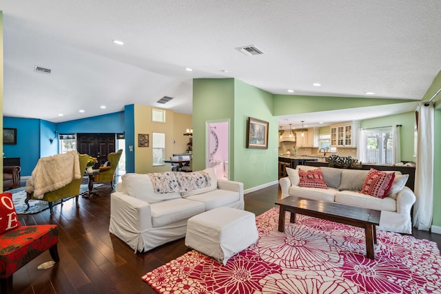 living room with dark hardwood / wood-style flooring, a textured ceiling, sink, and lofted ceiling