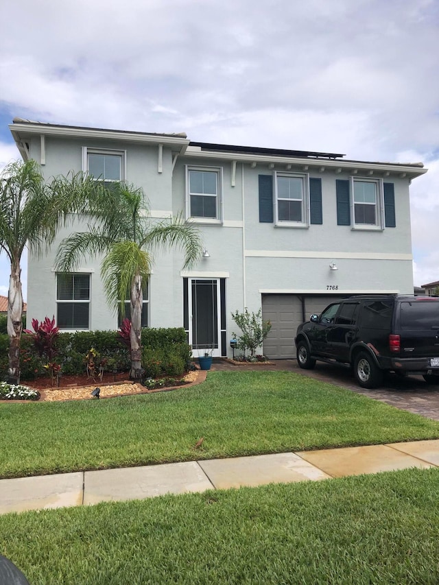 view of front of home with a front lawn and a garage