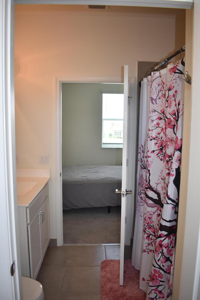 bathroom featuring vanity, tile floors, and toilet