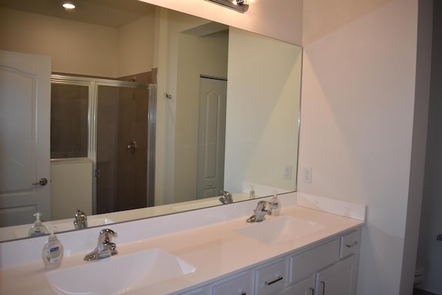 bathroom featuring double vanity and an enclosed shower