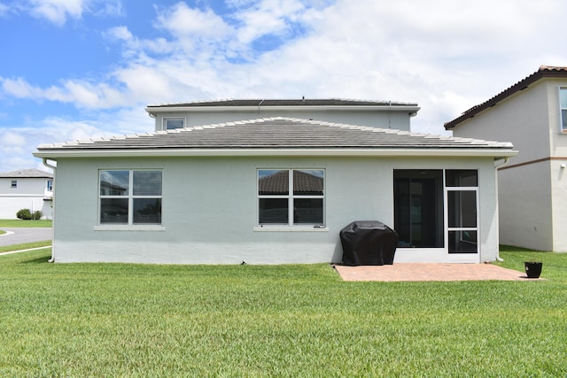 back of house with a lawn, a patio area, and a sunroom