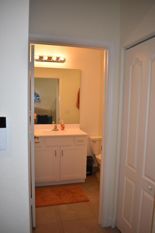 bathroom featuring vanity, tile flooring, and toilet