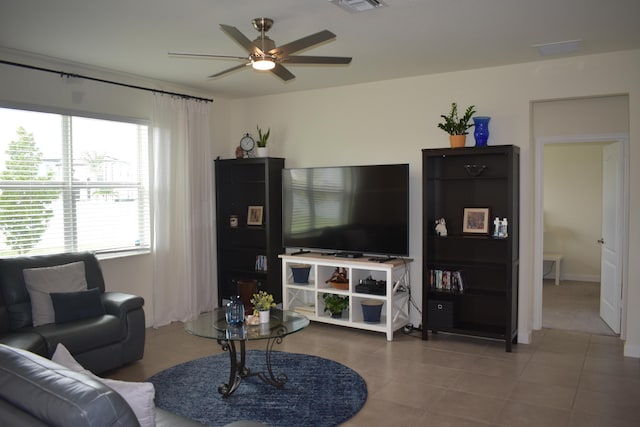 living room featuring light tile floors and ceiling fan