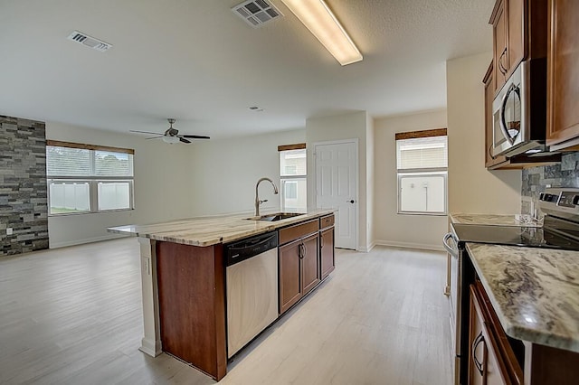 kitchen featuring plenty of natural light, stainless steel appliances, ceiling fan, and light wood-type flooring