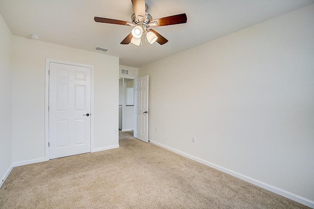 unfurnished bedroom featuring light colored carpet and ceiling fan