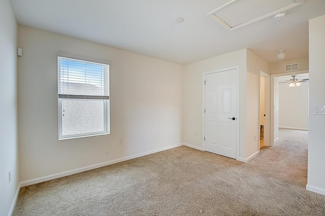 carpeted spare room featuring ceiling fan