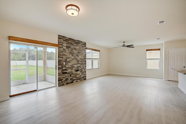 unfurnished living room featuring plenty of natural light, ceiling fan, and light hardwood / wood-style flooring